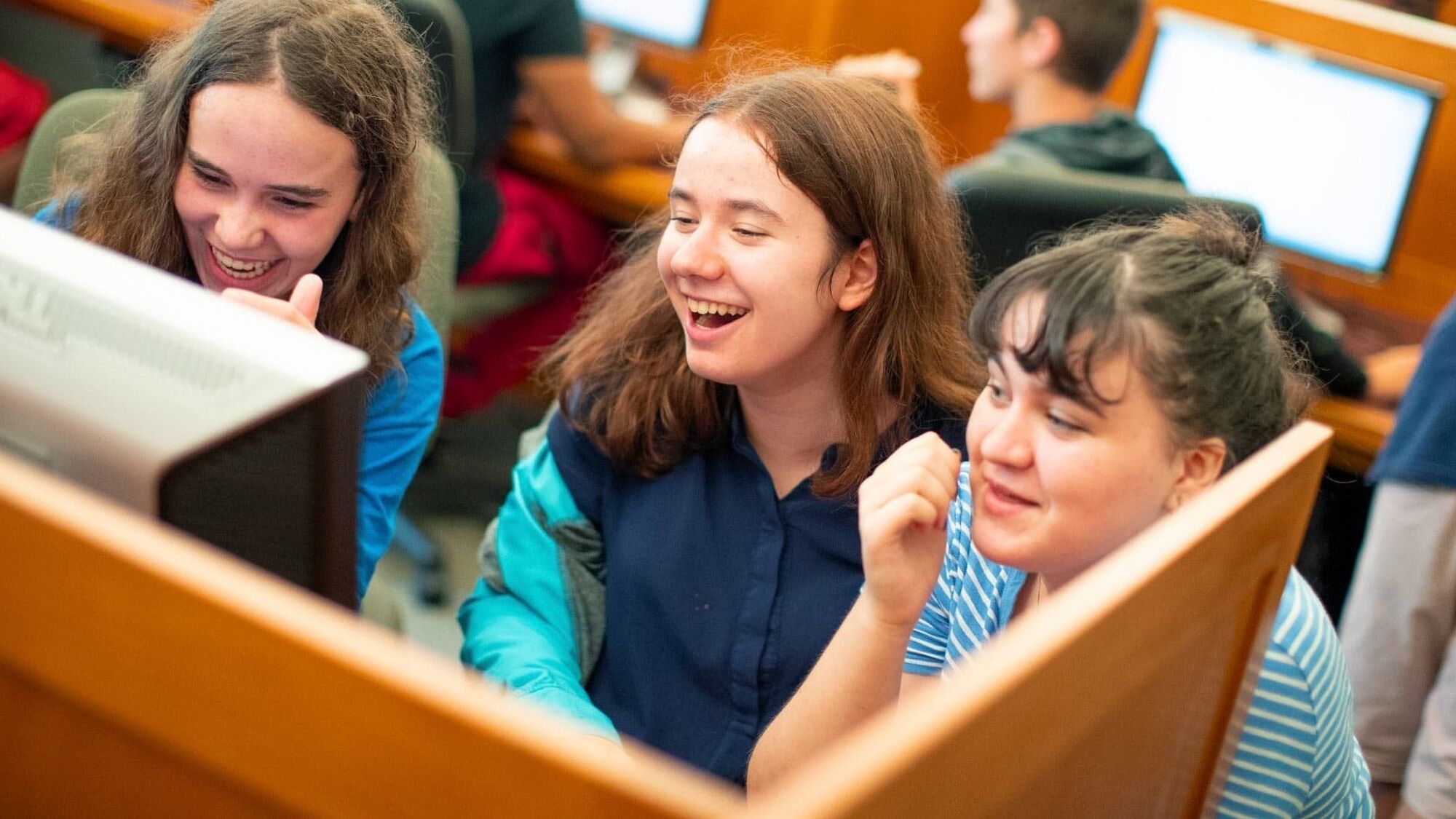 3 girls laughing at computer