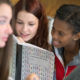 Two teens sharing writing classroom